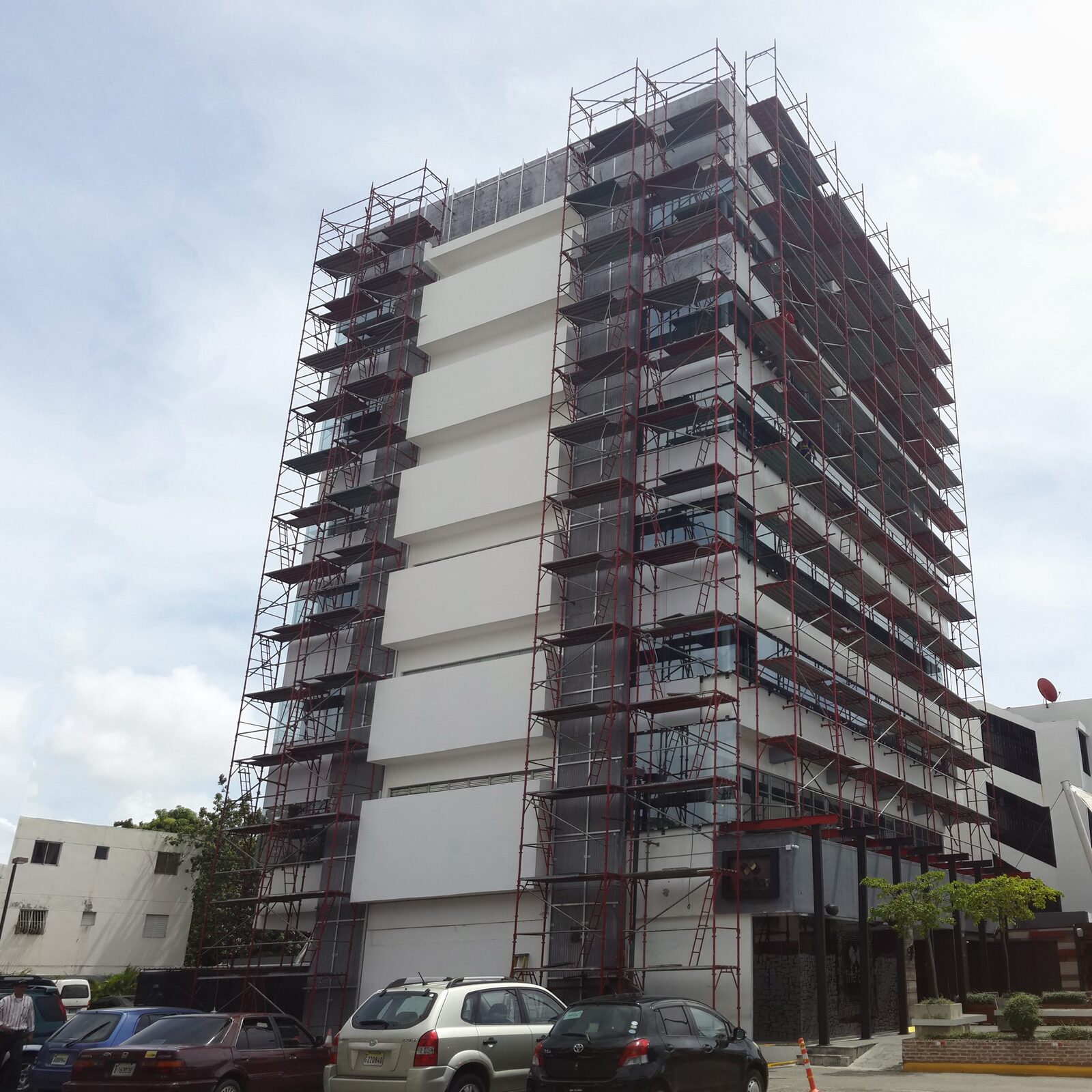 Fotografía del edificio W69 completamente cubierto de andamiaje durante el proceso de renovación de fachada.