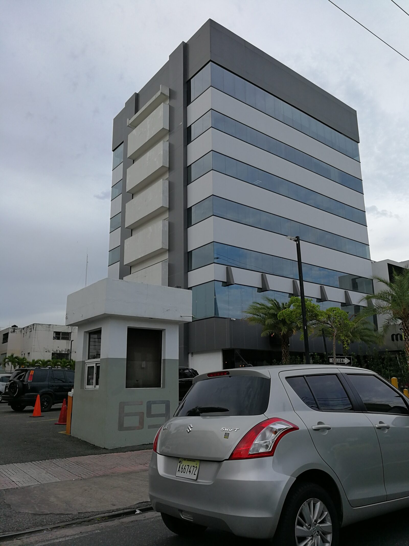 Fotografía del edificio W69 terminado con la caseta de control de acceso y el número 69 en el muro de entrada.